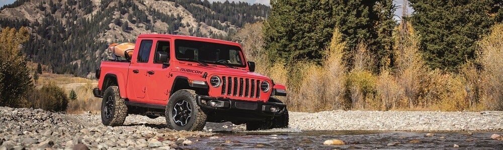 Jeep Gladiator driving over rocks and water