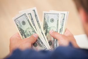 Cropped image of man counting fifty dollar bills at home