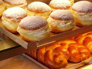 Bakery racks with cream puffed pastries and bread.