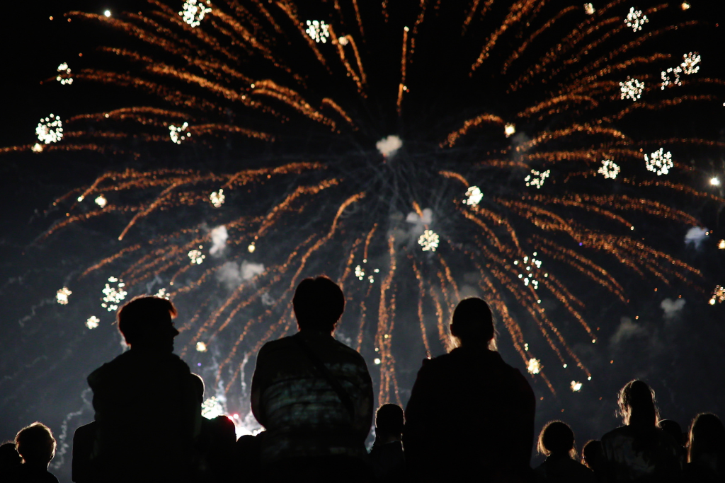 Silhouettes of people watching vibrant Fourth of July fireworks in Vallejo, California