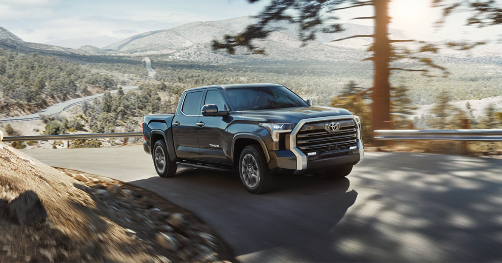 2024 Toyota Tundra in the midnight black metallic color driving up a mountain road.