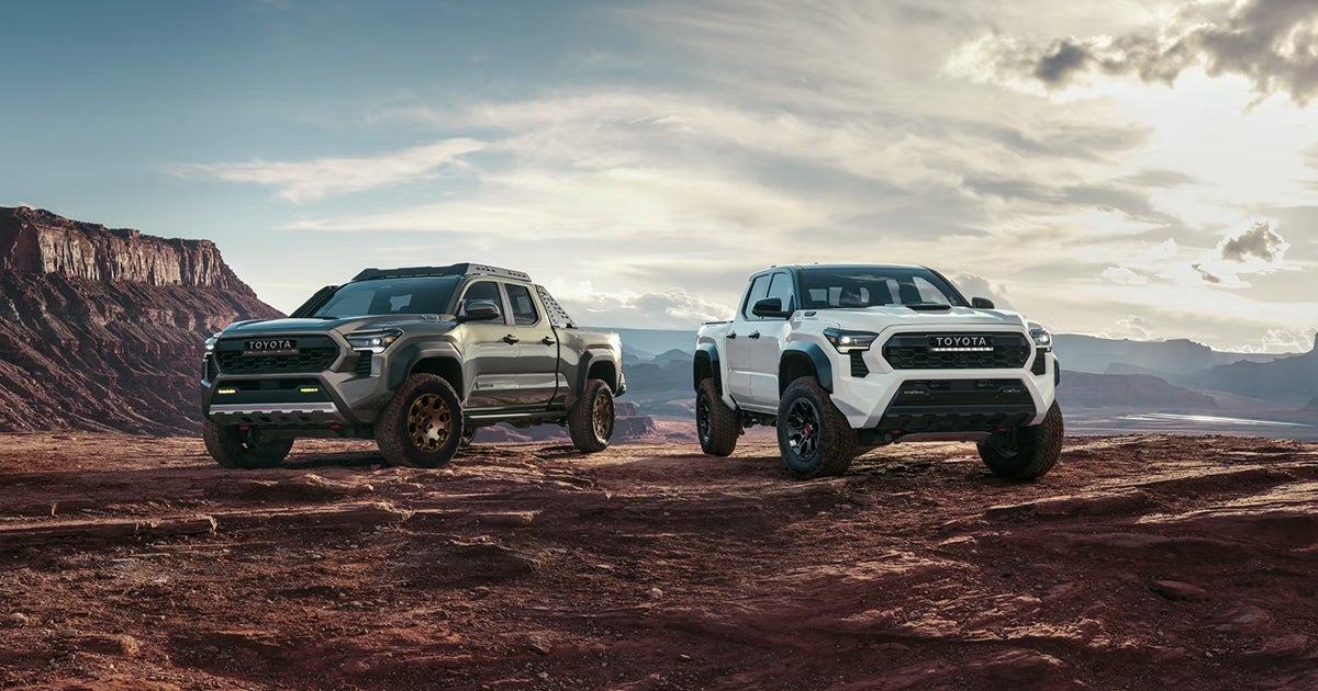 Two Toyota Tacoma trucks parked off-road by canyons.