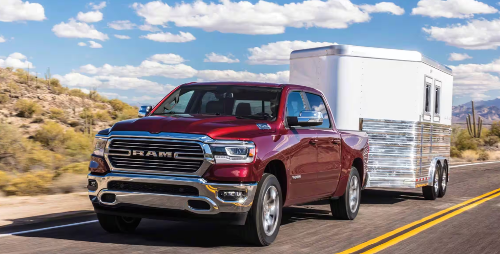 red 2024 RAM 1500 towing a trailer