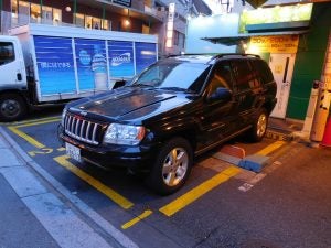 Black Jeep Grand Cherokee in a parking spot.