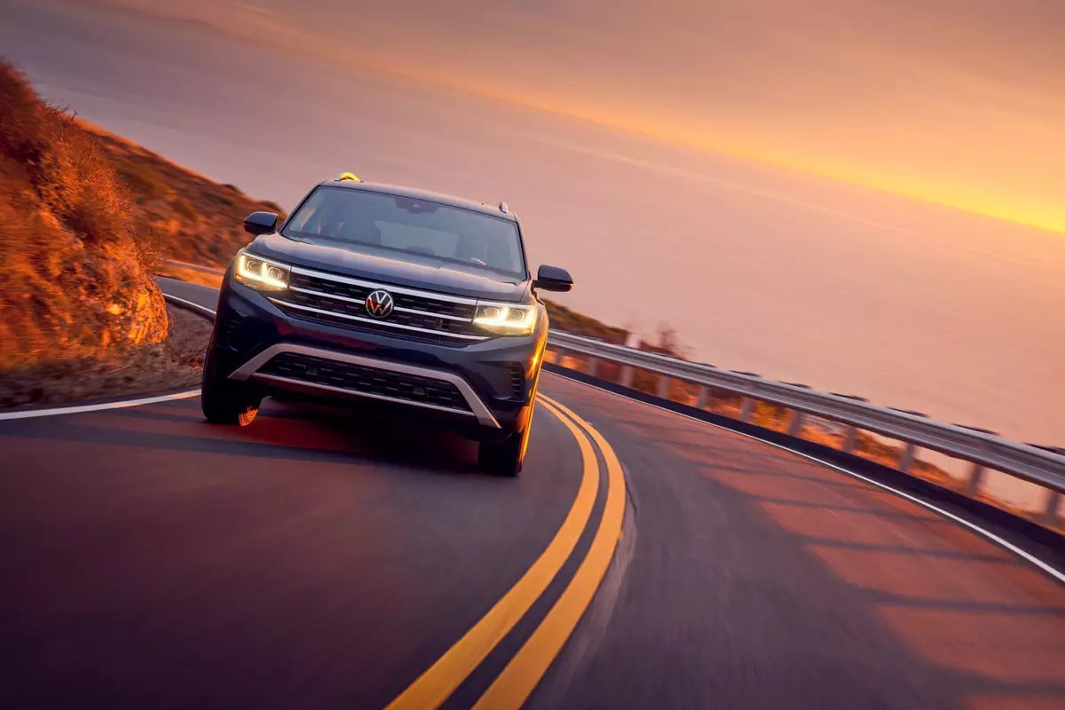 A Volkswagen drives on the open road during a summer sunset.