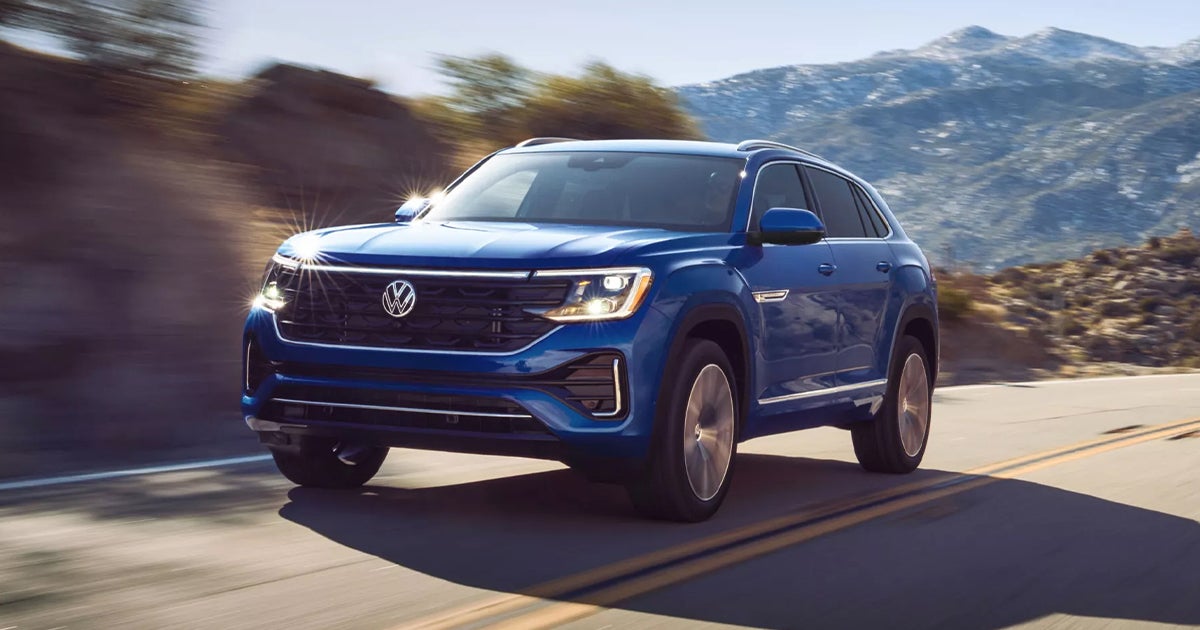 A blue 2026 Volkswagen Atlas Cross Sport driving on the highway