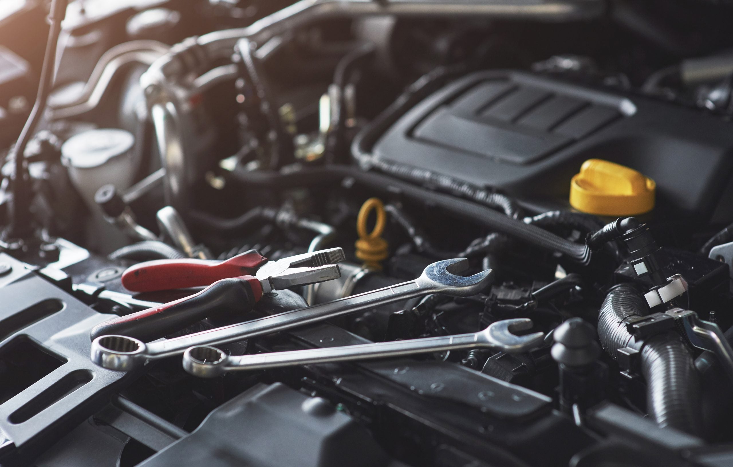 Mechanic hand checking and fixing a broken car in car service garage