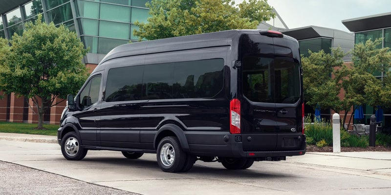 2026 Ford Transit passenger van parked outside a modern building.