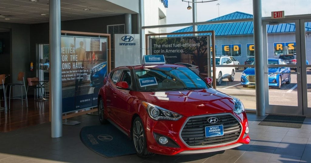 A 2016 Hyundai Veloster on display inside of the Wyatt Johnson Hyundai dealership.