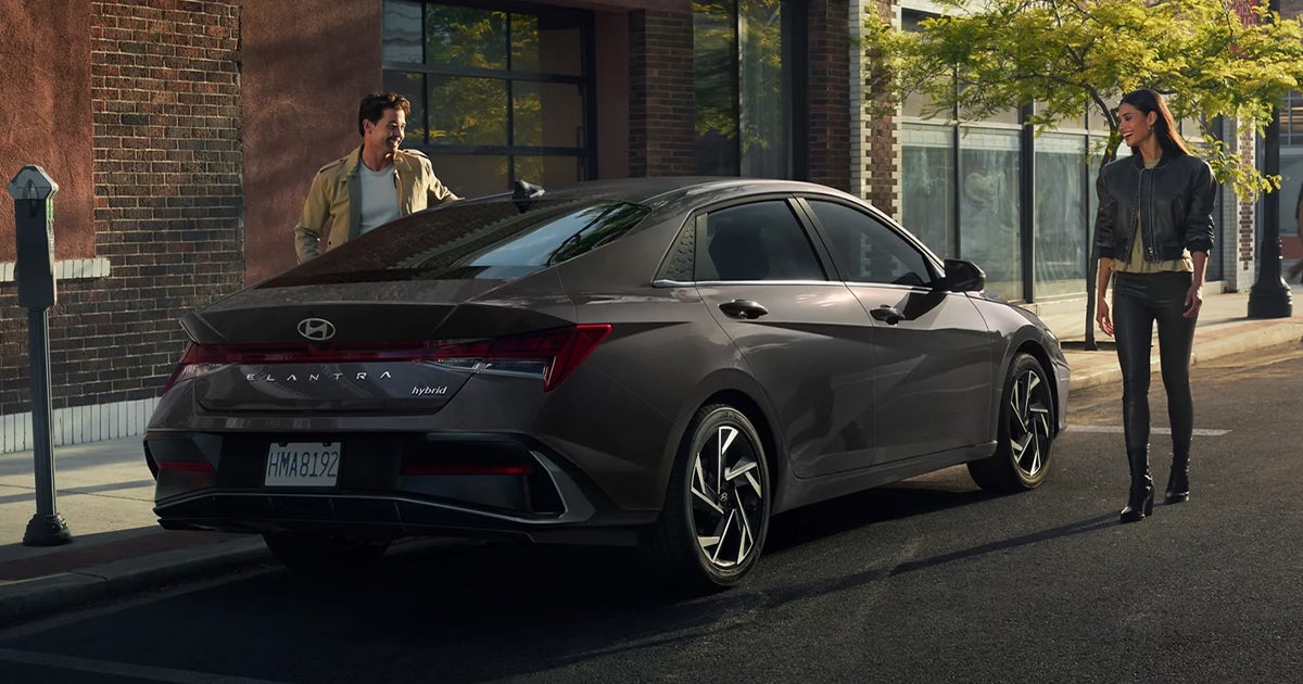 A dark grey Hyundai Elantra Hybrid parked on a city street.
