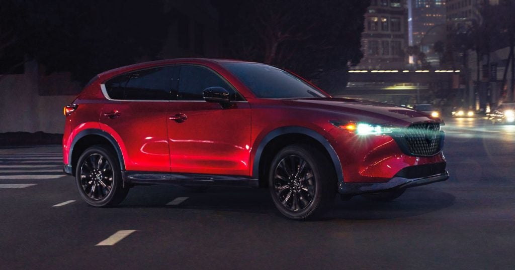 Red Mazda CX-5 driving through a city at night