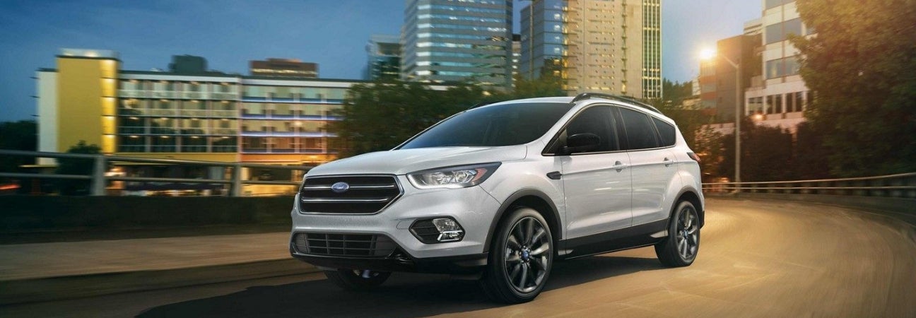 Whit 2019 Ford Escape driving with city in backdrop