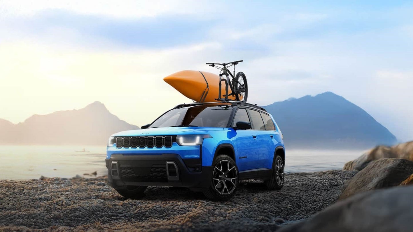 Blue 2026 Jeep Cherokee parked on a rocky beach