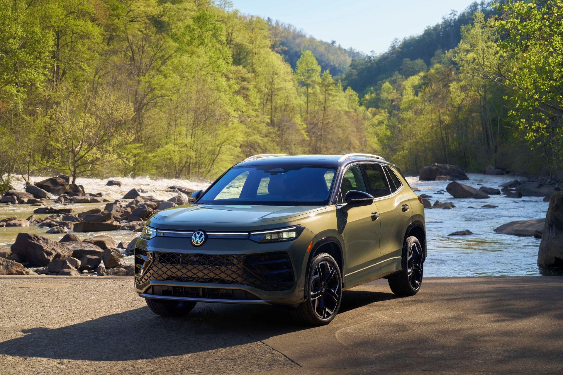 The Magnificent 2026 Volkswagen Tiguan In Front Of A Glorious River With Rocks Sprinkled Around.