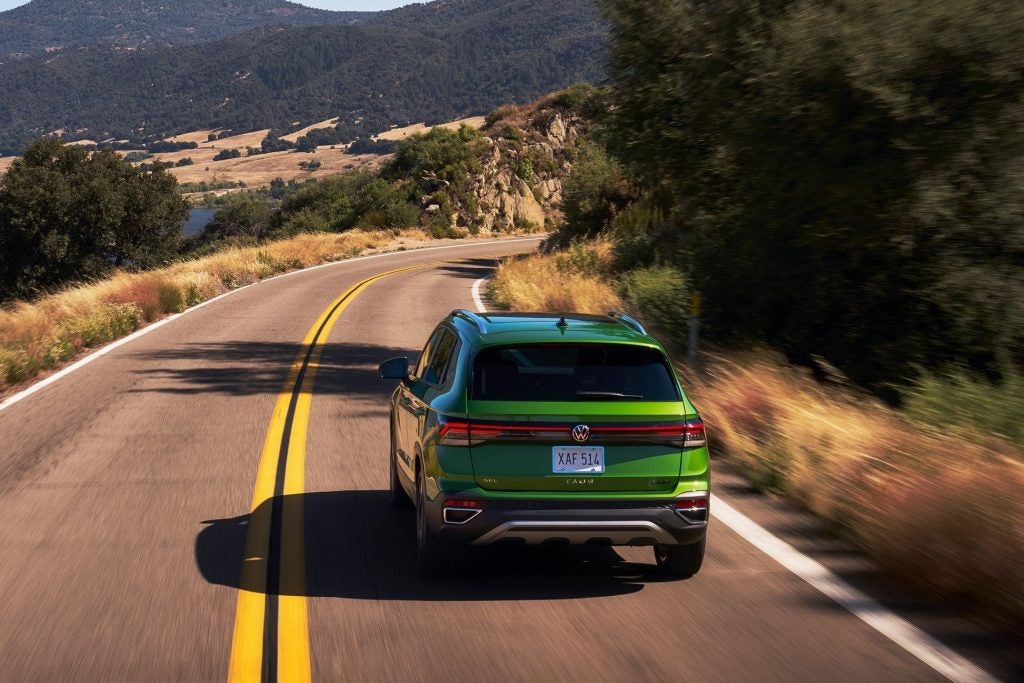 The Enchanting Green Volkswagen Taos Driving Down A Winding Road, The Driver Enjoying The Satisfying Seat Cooling After A Long, Hot Day