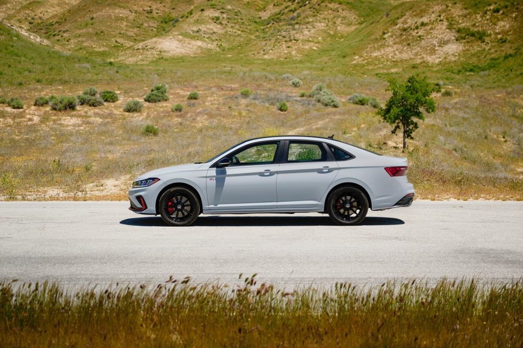 The Attractive Volkswagen Jetta GLI Driving Parked Near A Gorgeous Mountain With Beautiful Greenery