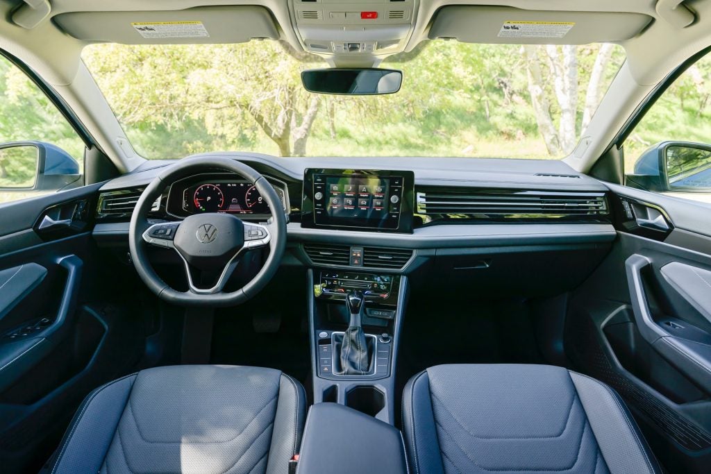 A Jetta Model's Black Trimmed And Sleek Interior With Multiple Technological Features
