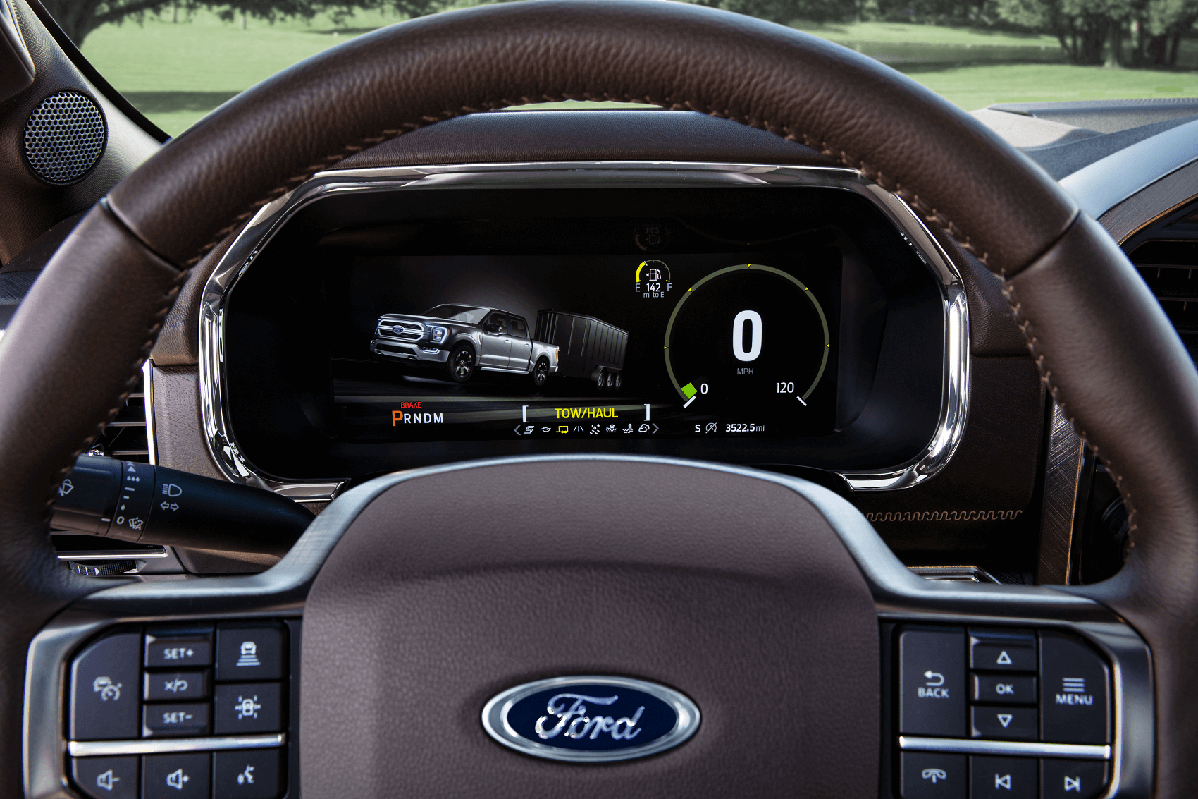 An up close of the dark brown leather steering wheel and dash of the 2021 Ford F-150.