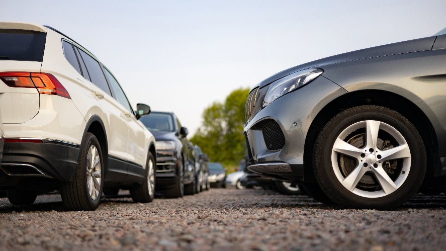 Several cars parked on a dealership lot.