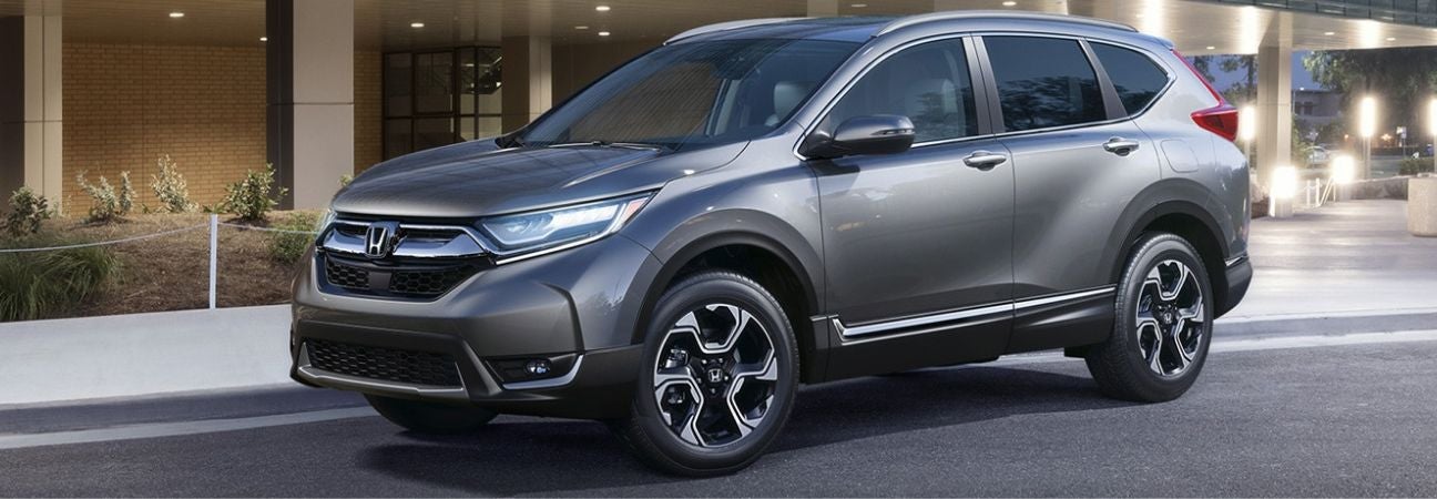 Silver 2019 Honda CR-V parked in front of a building in a city.