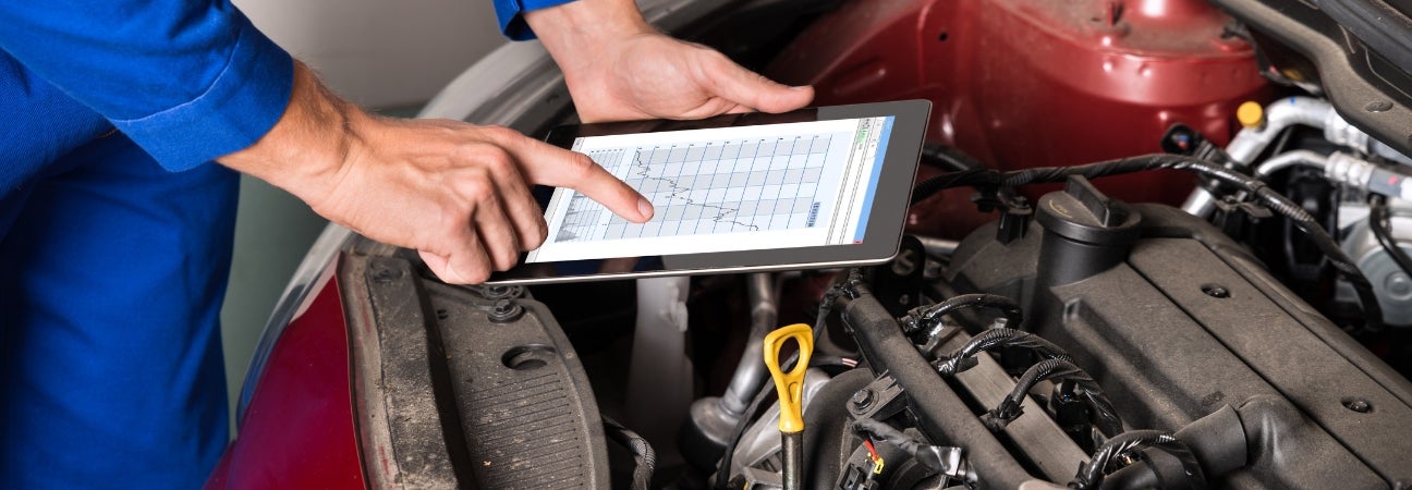 technician performs season auto service on car engine