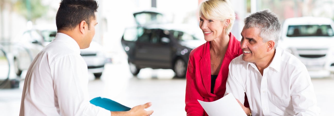 Couple talking to car salesman
