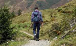 man walking a trail in the mountains 