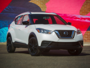 white nissan kick black wheels with colorful brickwall