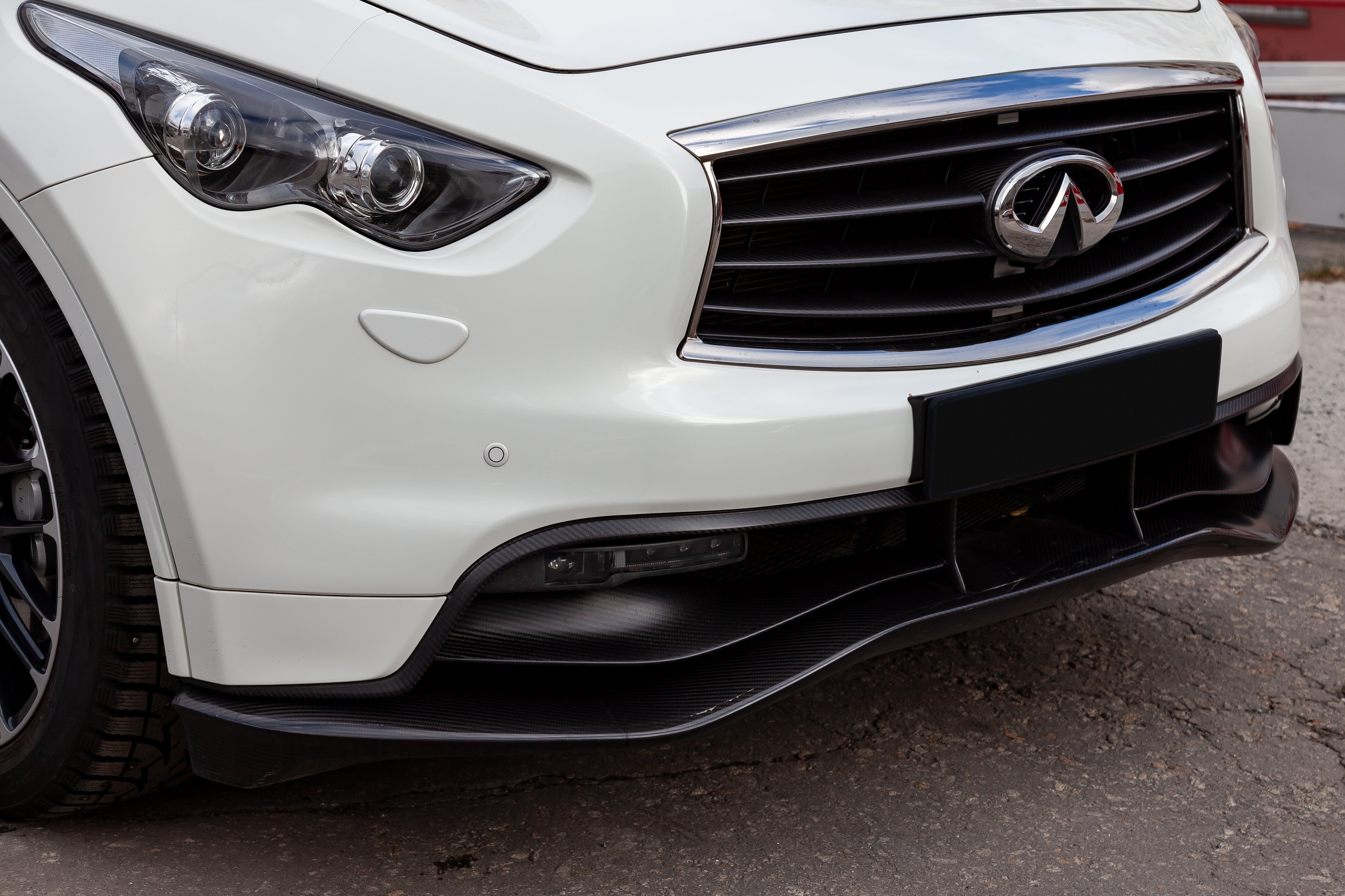 White Infiniti FX35 FX45 FX50 QX70 in Sebastian Vettel Limited Edition tuning front bumper view on the car parking in the street