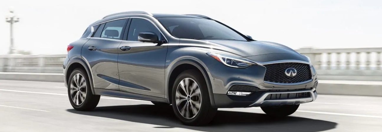 2019 INFINITI QX30 in silver driving on a bridge