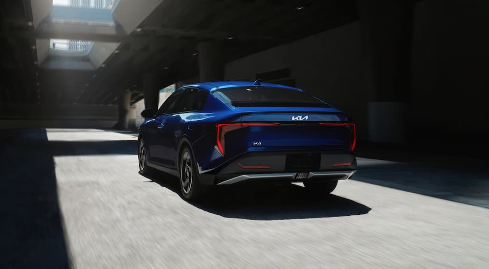 A blue 2026 Kia K4 driving in a tunnel