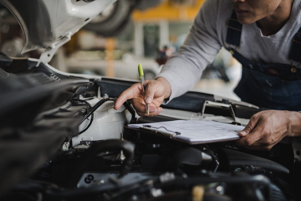 Mechanic checking a car in an auto repair shop.