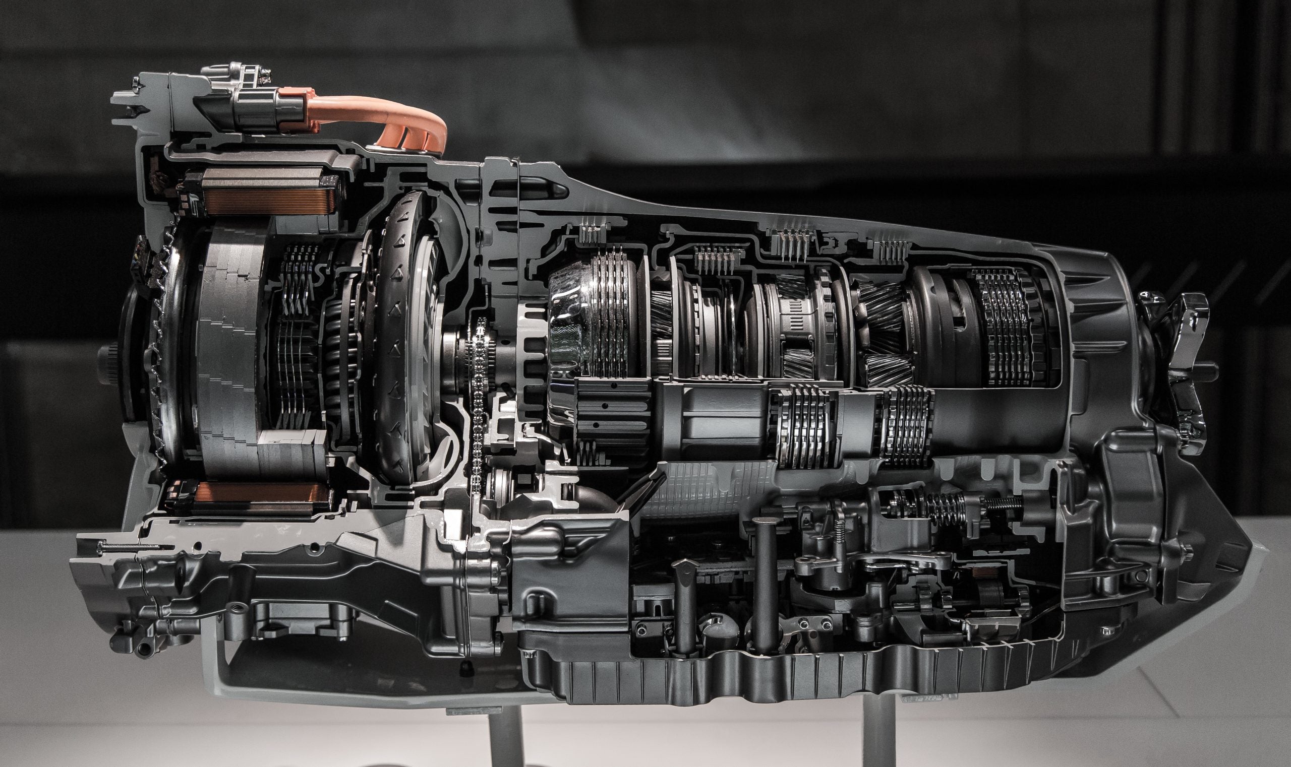 A cutaway view of a complex car engine showcasing gears, turbines, and electrical components.