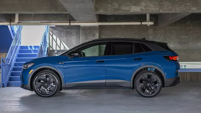 Blue Volkswagen SUV shown in side profile parked inside a concrete parking garage.
