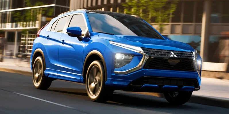 A blue 2025 Mitsubishi Eclipse Cross driving down the road.