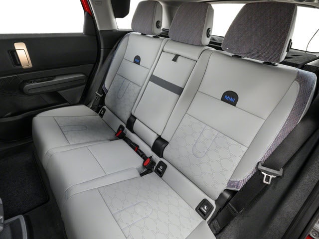 Back seats of a 2025 MINI Countryman SE ALL4 with light gray upholstery and headrests, designed for comfort.