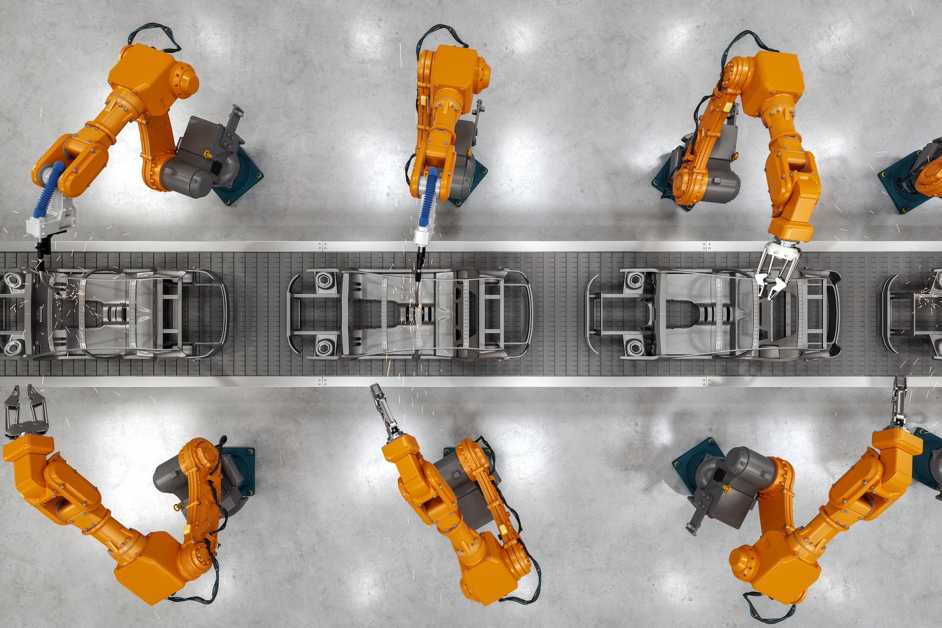 Top view of industrial welding robots at the automated car manufacturing factory assembly line.