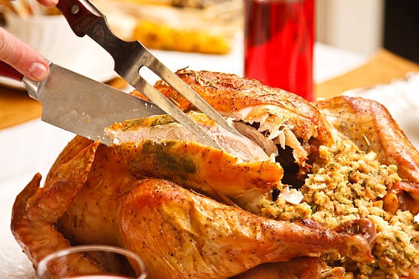 A person carving a turkey