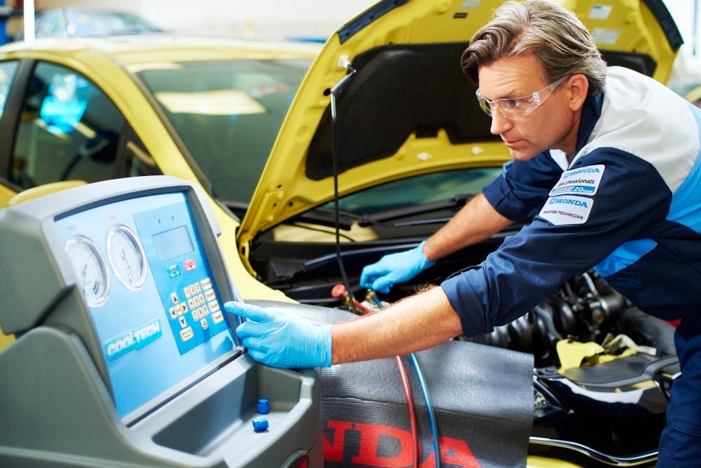 Boyd Honda mechanic running diagnostics on a yellow vehicle in the shop.