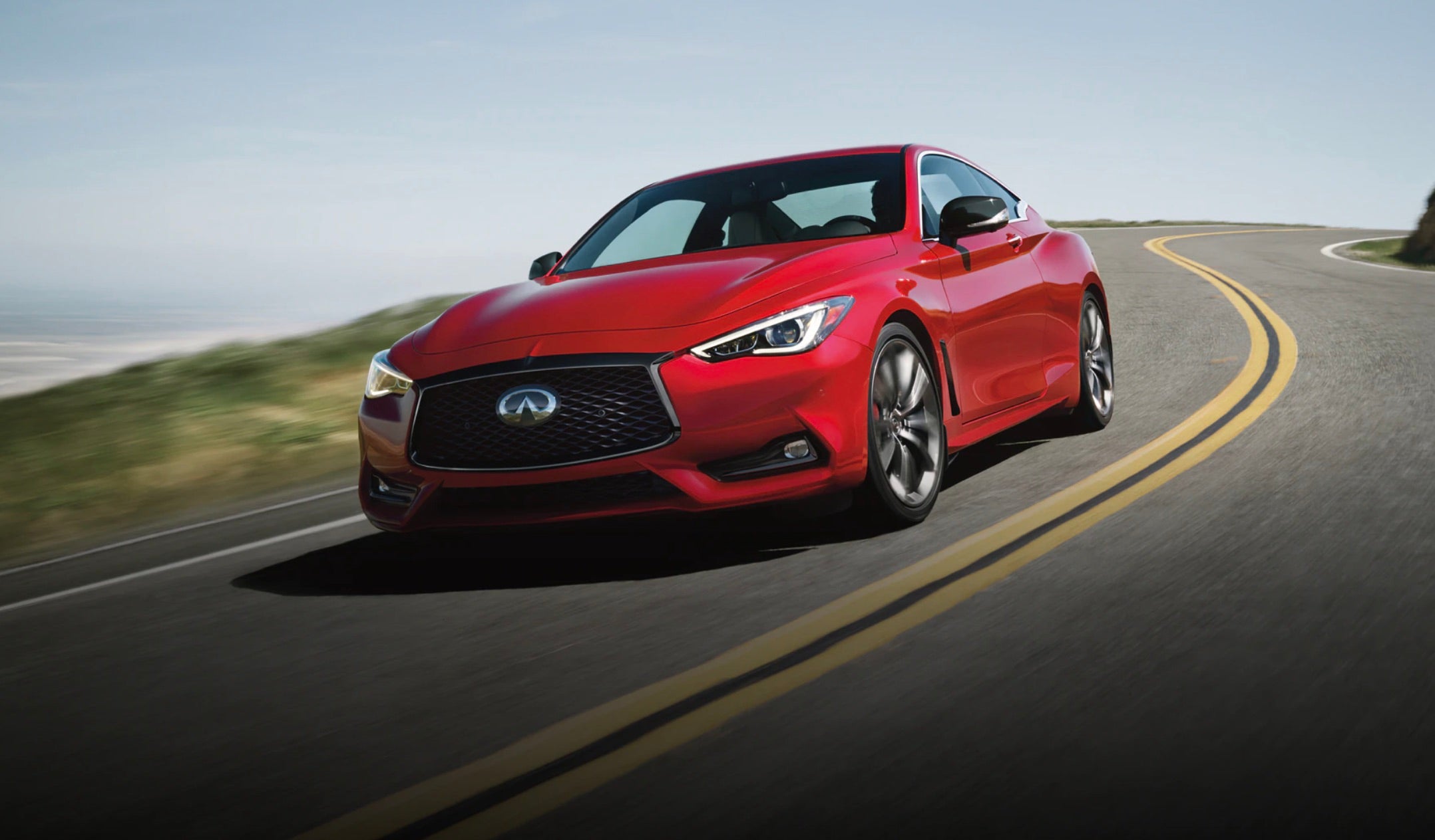 A red 2022 Infiniti Q60 driving down the road