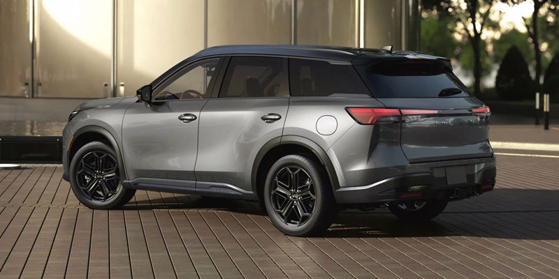 Silver Infiniti QX60 SUV parked outdoors with a black roof and alloy wheels.