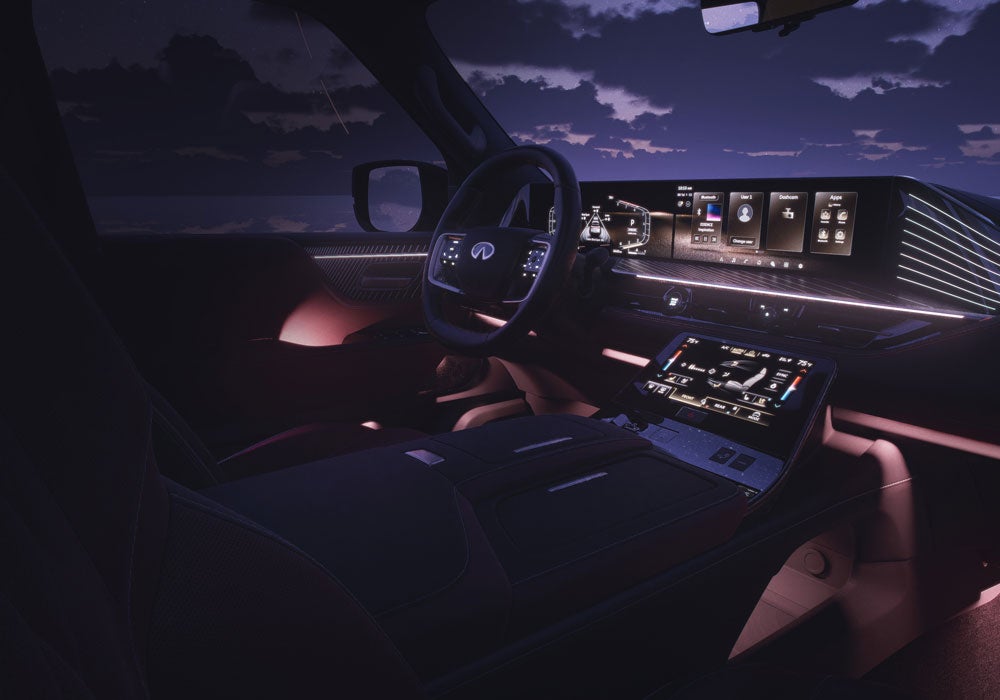 Interior of a luxury Infiniti car, showcasing a futuristic dashboard with multiple screens and ambient lighting under a night sky.