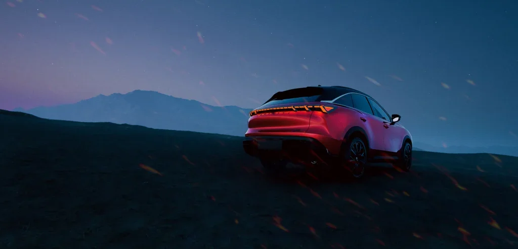 2027 INFINITI QX65 with illuminated tail lights against a twilight mountain backdrop.