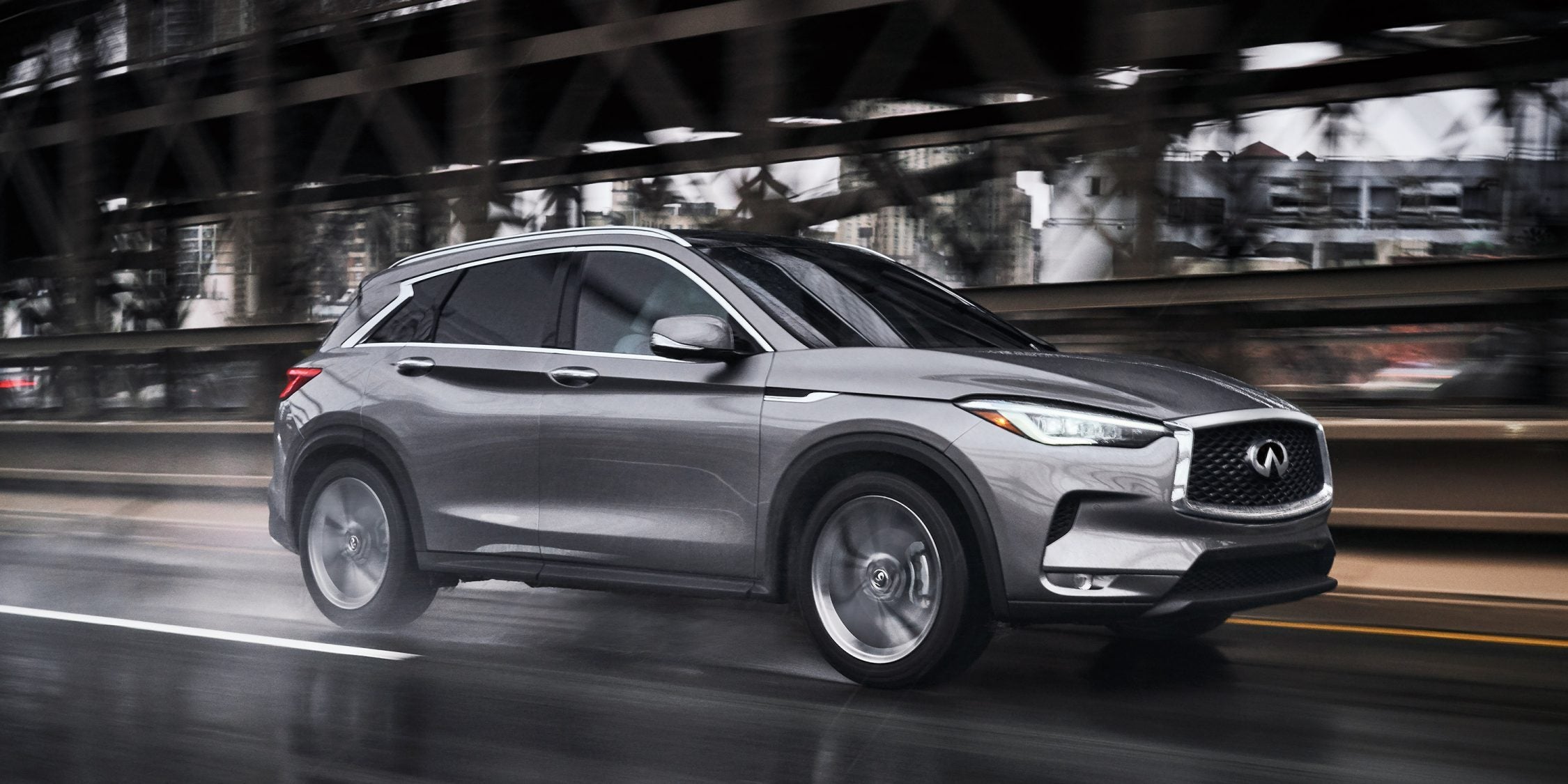 A silver 2022 Infiniti QX50 vehicle driving on the road