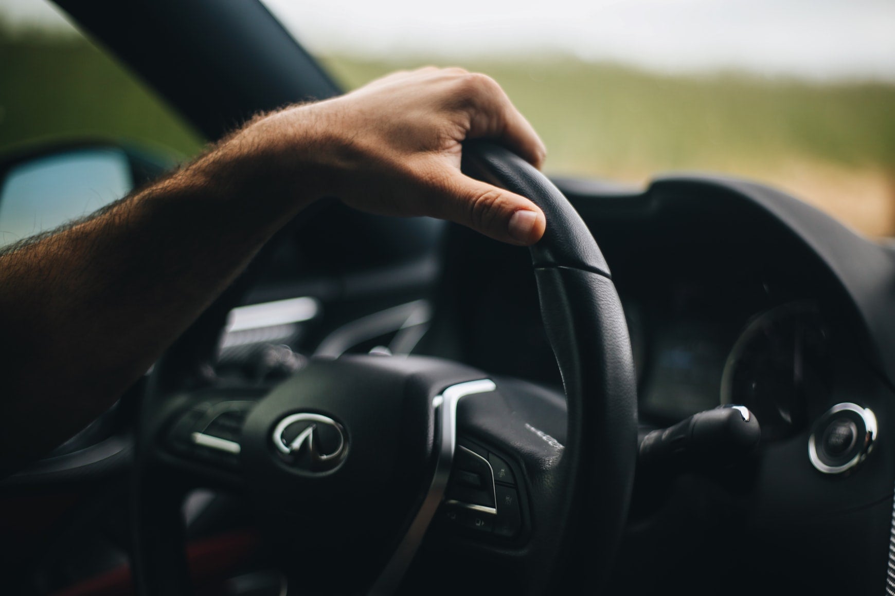 A person driving an Infiniti luxury vehicle