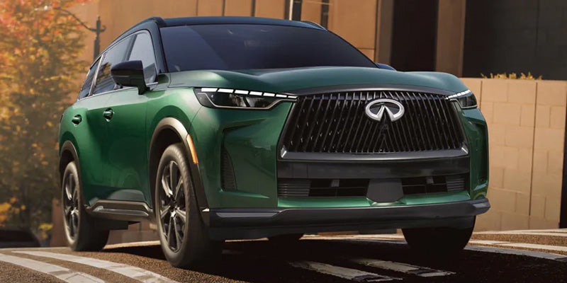 Front view of a green Infiniti SUV parked outdoors in a residential driveway.
