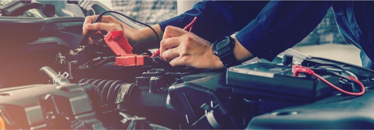 a car mechanic working under the hood of a car