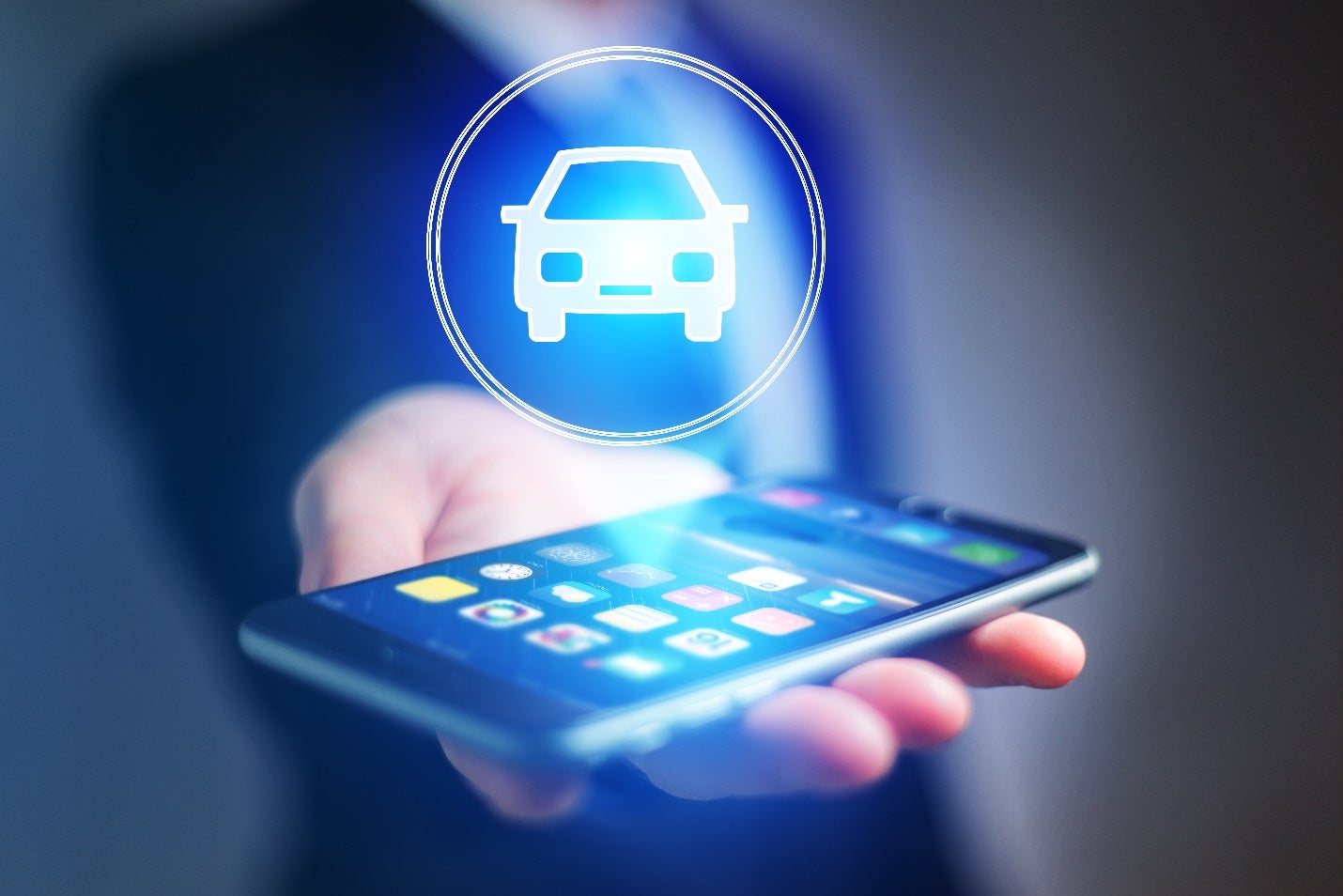 businessman hand holding mobile phone with car icon