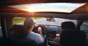 A guy texting while driving with a woman in the passenger seat | Bob Ruwart Motors