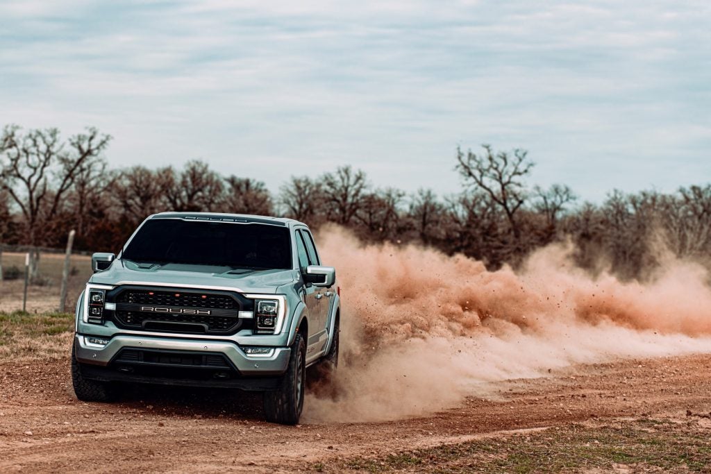 Ford Rousch F150 driving down a dirt Road